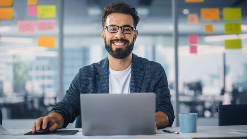 a man sitting at a desk with a laptop