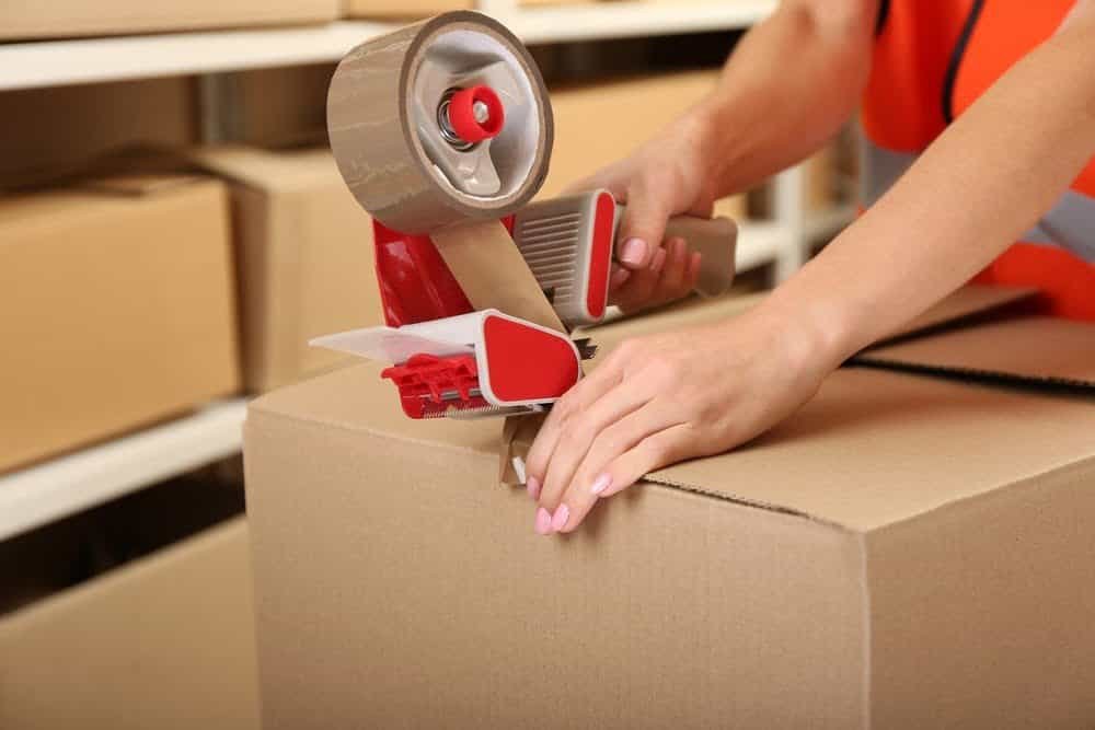 Taping a box in a warehouse